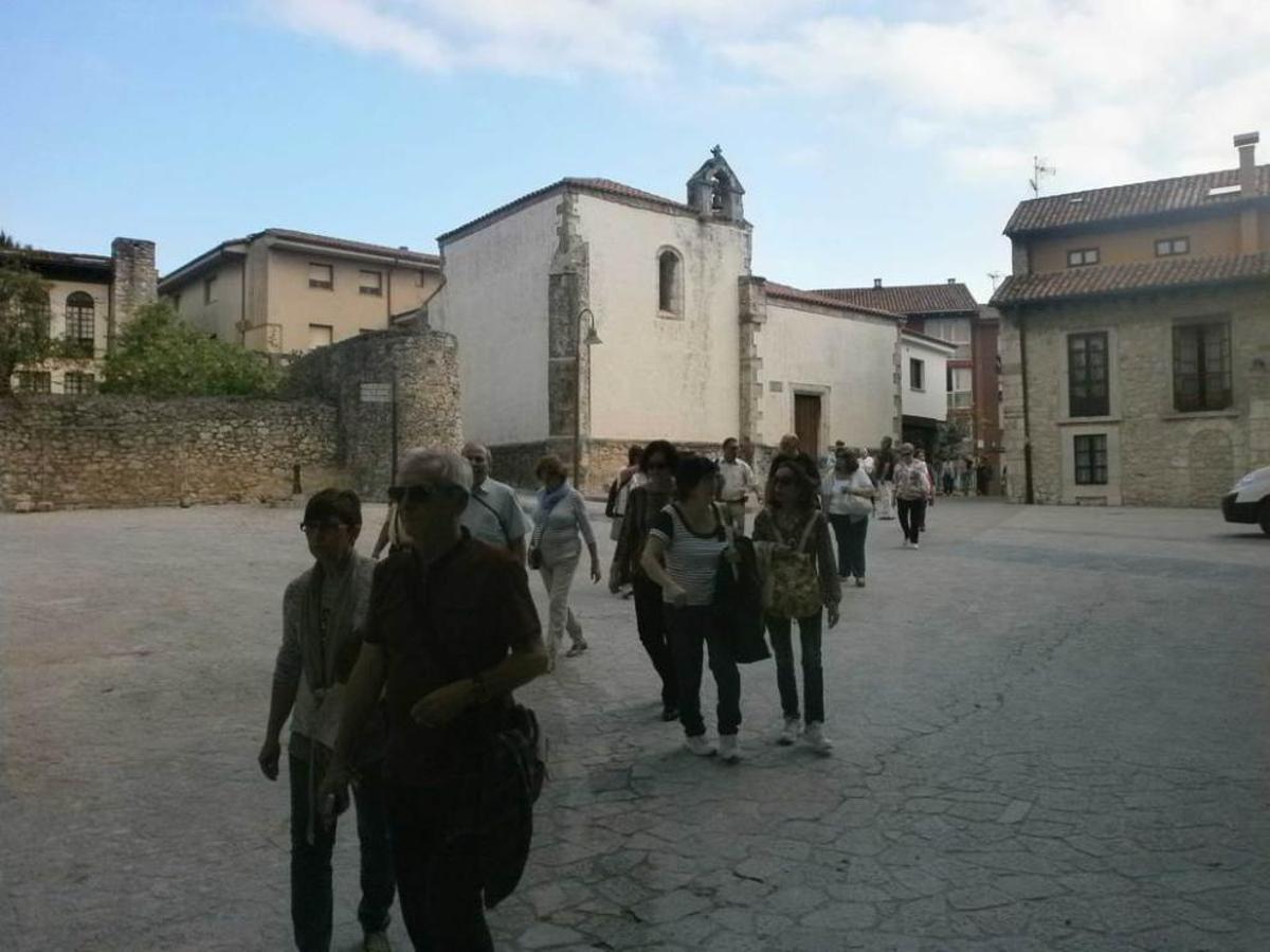 Turistas paseando por la plaza de Santa Ana de Llanes.