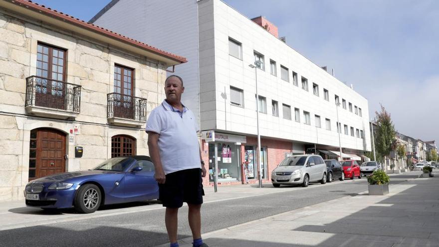 El denunciante, Alfonso Vidal, ante su casa y el edificio pendiente de demolición, en Sabarís. // José Lores