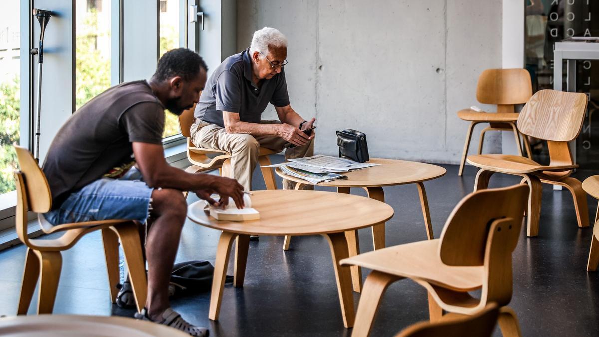 Dos usuarios de una biblioteca de Barcelona, en plena ola de calor este julio