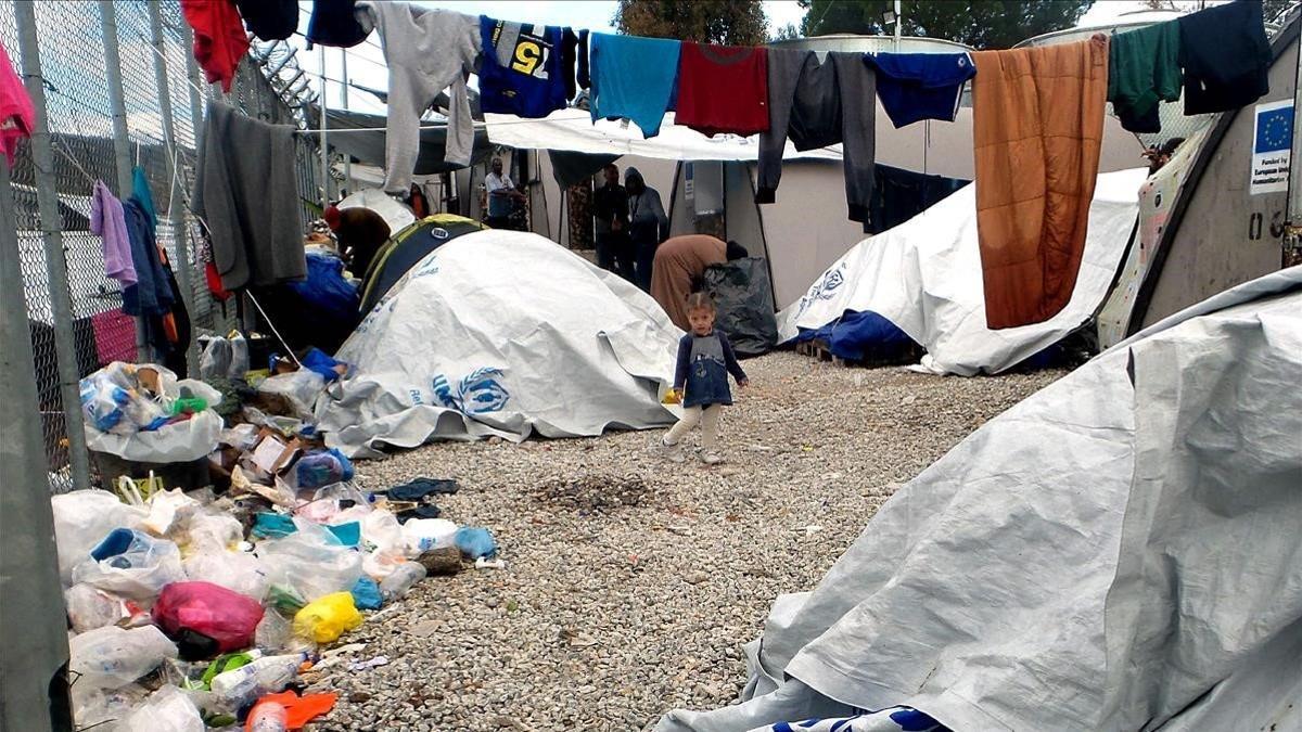 Un niña se encuentra entre las carpas en un campamento improvisado fuera del campamento de migrantes Moria en la isla de Lesbos