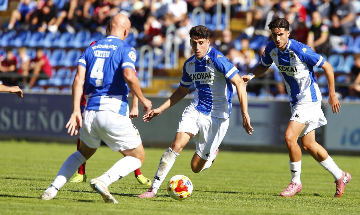 Roger Colomina, con el balón, junto a Rentero (i) y Unai Ropero (d), durante un partido en Teruel.