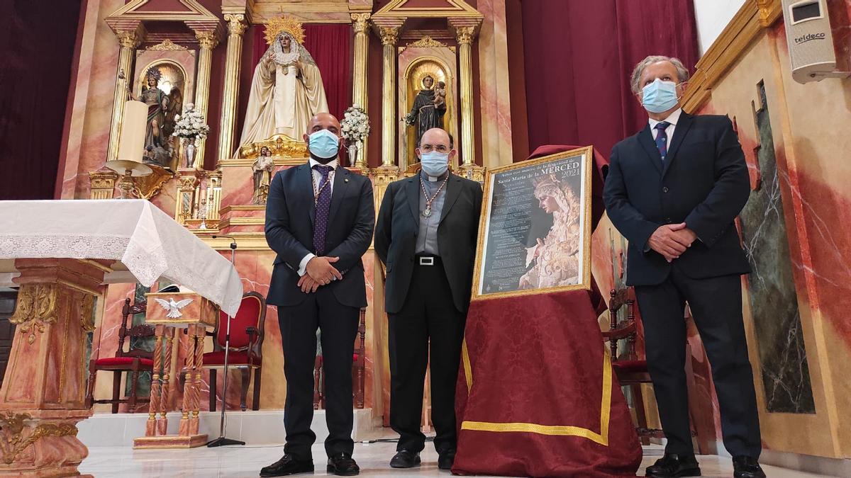 El hermano mayor de la Merced, el párroco de San Antonio y el concejal Salvador Fuentes, junto al cartel.