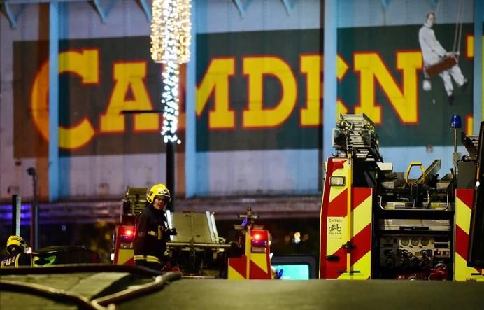 A firefighter walks at the scene of a fire at ...