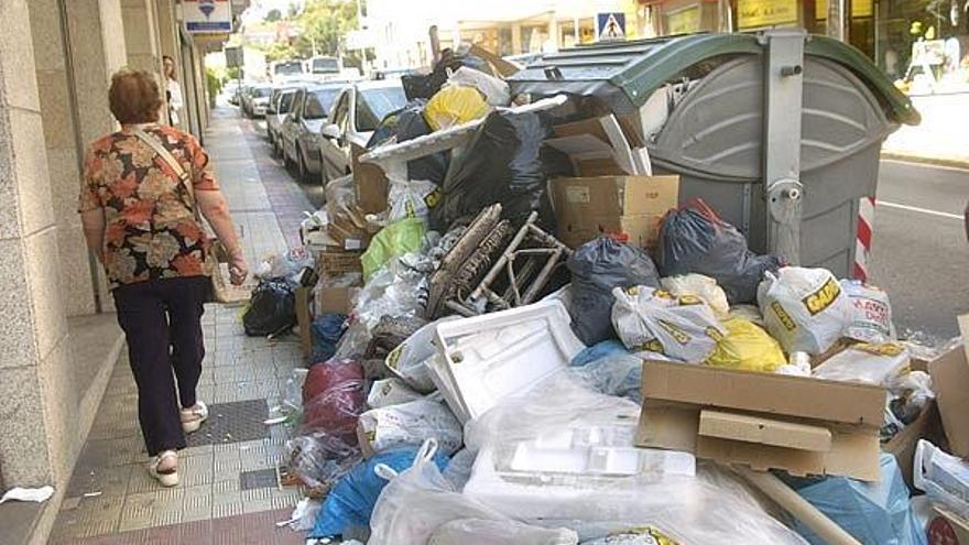 La acumulación de bolsas de basura en las aceras impide en algunas zonas el tránsito de peatones.