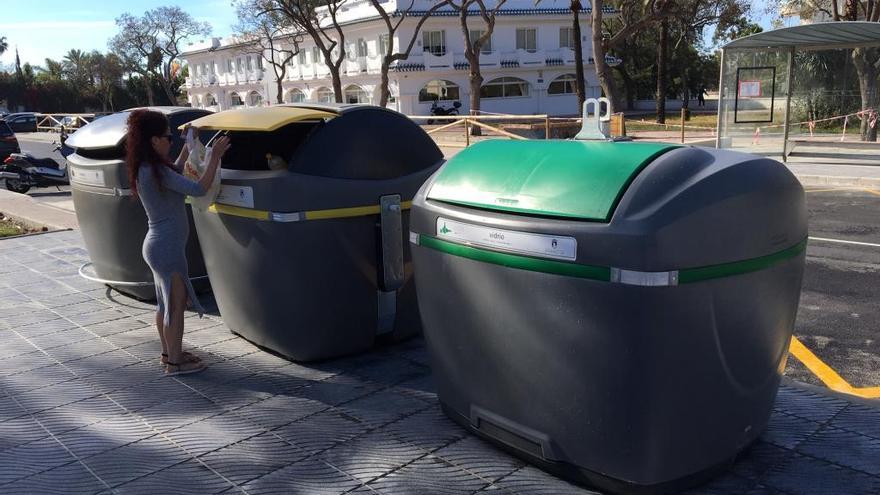 Una vecina tira la basura en uno de los nuevos contenedores.