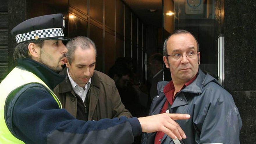 Un policía charla con dos peritos el día después del desalojo. / e. vicente