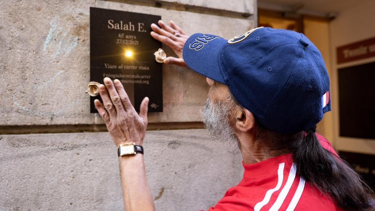 Alí coloca en la calle una placa en recuerdo a su amigo Salah, fallecido en 2021, en una acció por el recuerdo promovida por la fundación Arrels el pasado martes.
