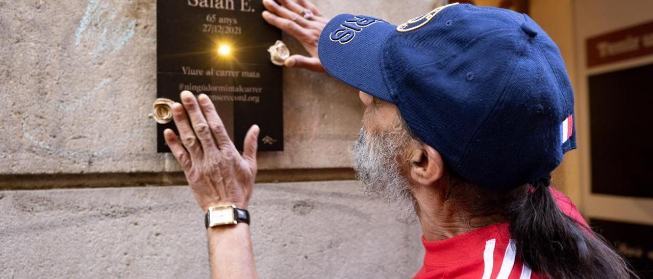 Alí coloca en la calle una placa en recuerdo a su amigo Salah, fallecido en 2021, en una acció por el recuerdo promovida por la fundación Arrels el pasado martes.