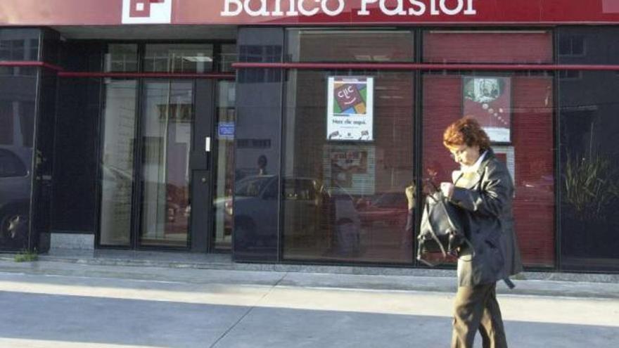 Una mujer pasa por delante de una oficina del Banco Pastor. / la opinión