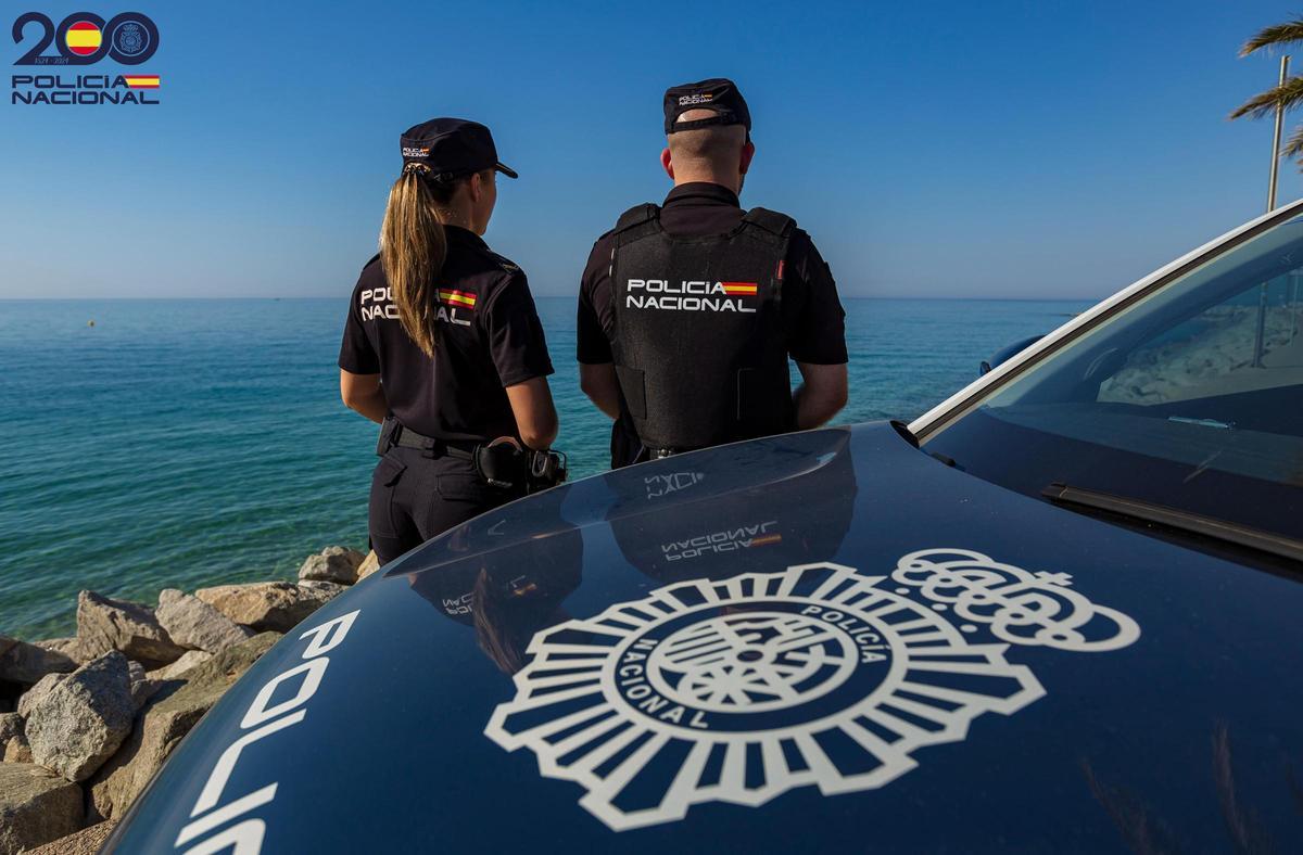 Una pareja de agentes de la Policía Nacional frente al mar
