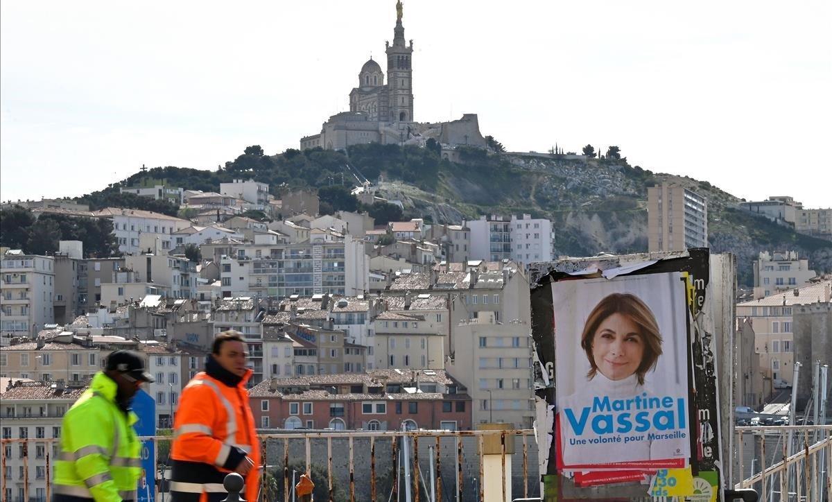 zentauroepp52627227 workers walk past an electoral poster of martine vassal  mem200306163035