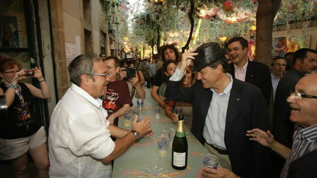 Artur Mas bromea con un vecino de Gràcia durante su visita al barrio.