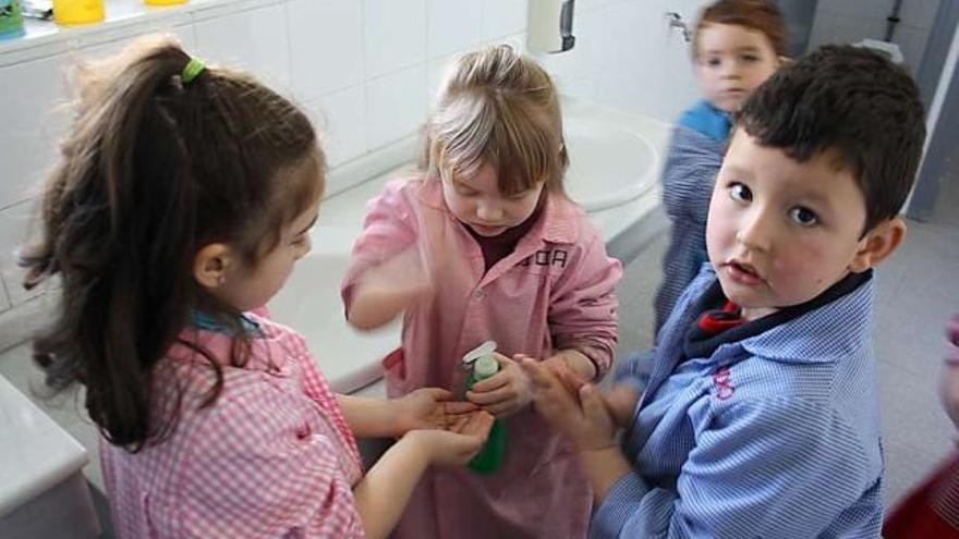 Alumnos del Infantil del colegio de Boal se lavan las manos en el aseo del centro, antes del cepillado de dientes.