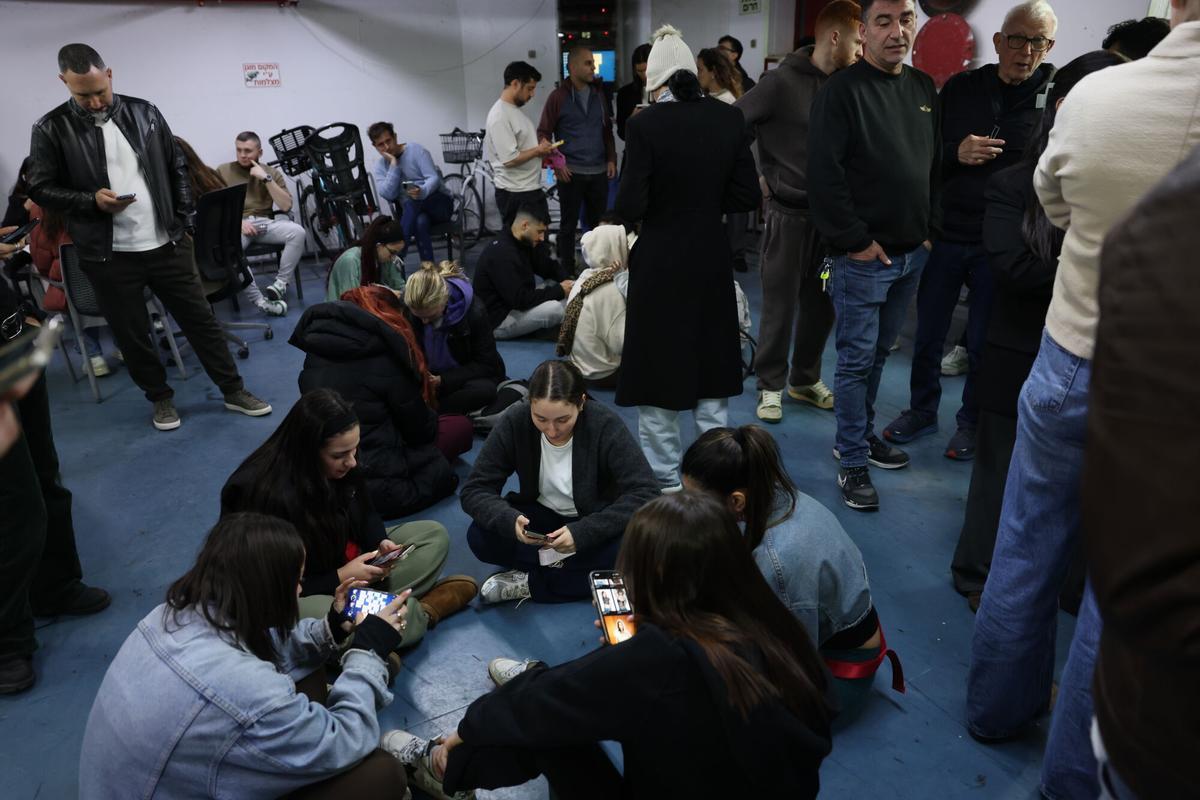 Vecino de Tel Aviv permanecen  en un refugio subterráneo para protegerse de un ataque iraní, este martes.