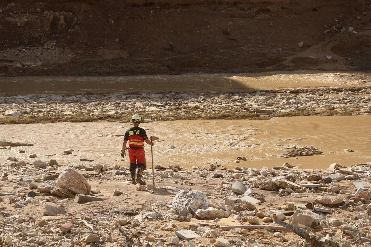 Un bombero del gobierno de Cantabria revisa el barranco de Paiporta a la búsqueda de posibles víctimas