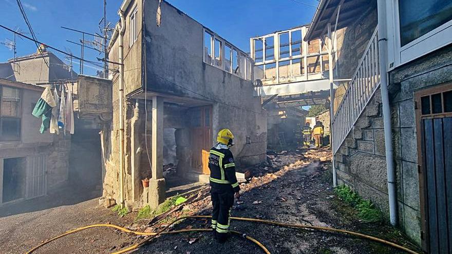 Un bombero frente a la vivienda calcinada.   | // FDV