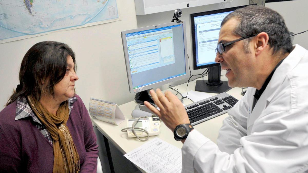 Un médico de un CAP de Salt (Gironès) habla con una paciente en su consulta.