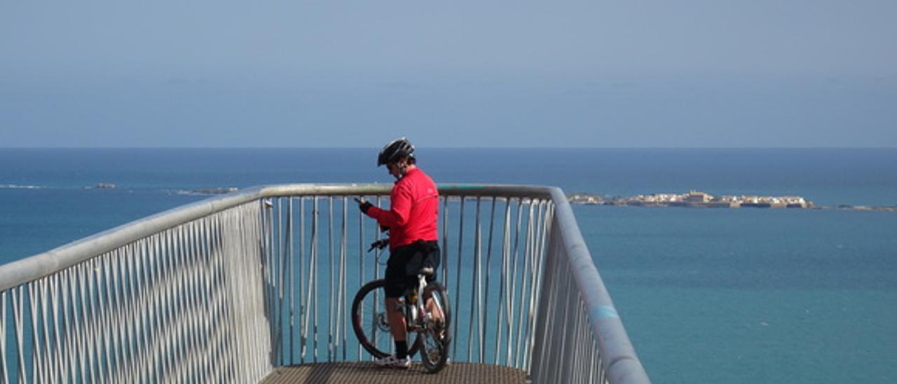 Un cicloturista en uno de los balcones de la isla