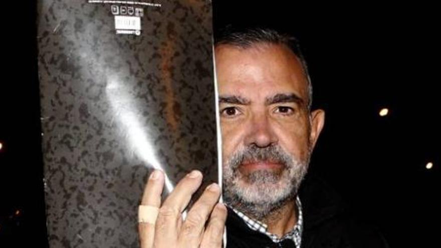 López Abad, con la carpeta con la que intentaba ocultar su rostro, mira a la cámara a su salida ayer de la prisión