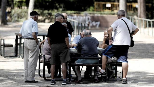 Diversos pensionistes juguen al dòmino en un parc de Madrid