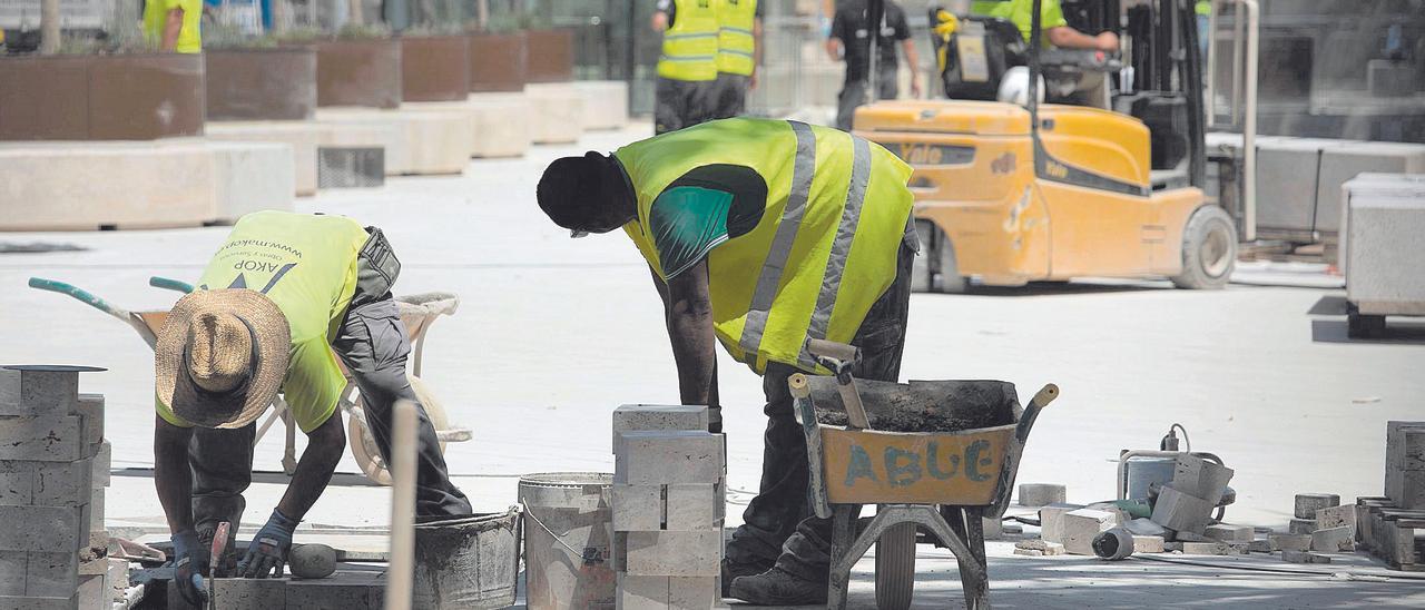 Dos trabajadores realizan tareas físicas durante la mañana en una de las obras del centro de la ciudad de València