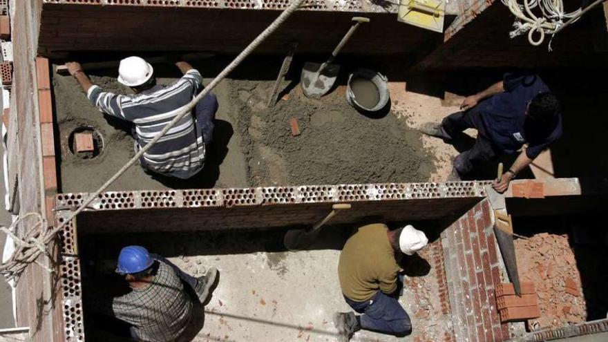 Cuatro obreros trabajan en la construcción de un edificio.