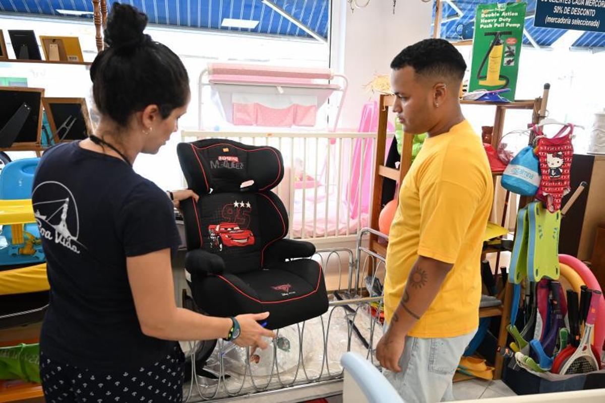 Un hombre busca artículos para bebé en la tienda solidaria de A Seca. |  // RAFA VÁZQUEZ
