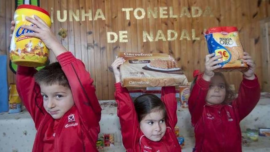 Tres alumnos de Escolapios, ayer, con productos donados.