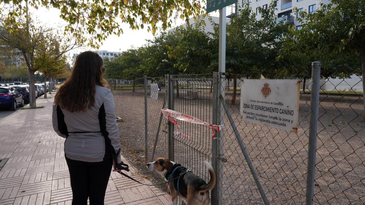 Una vecina, con su mascota, junto al centro de esparcimiento canino, cerrado, este martes.