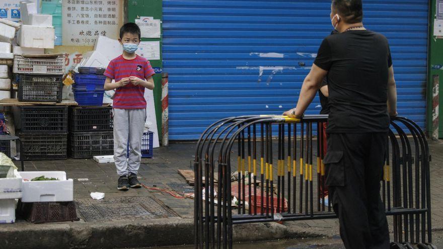 Un niño con mascarilla junto a un adulto en la capital china.