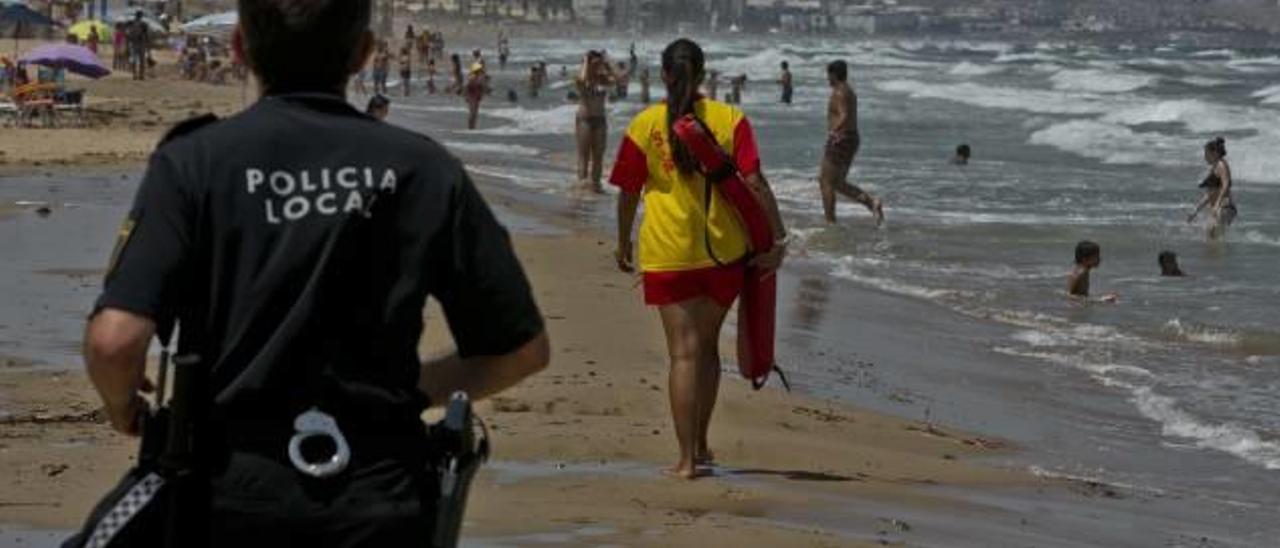 Agentes de la policía local y socorristas advirtiendo a bañistas ayer en los Arenales