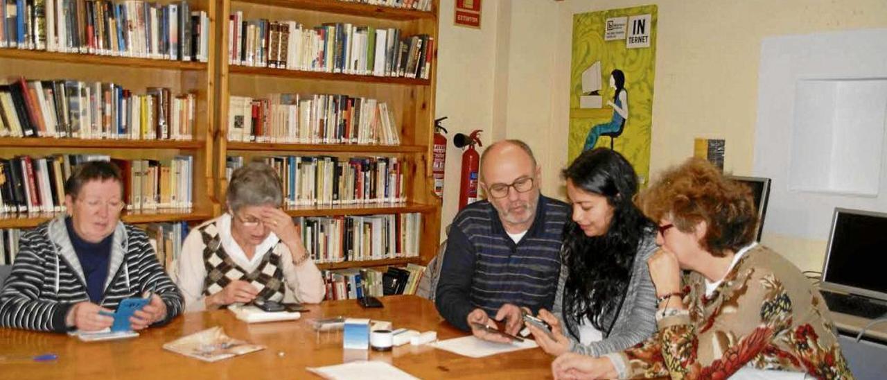 Algunos de los participantes en el taller manejan sus teléfonos inteligentes bajo la supervisión de la profesora Adriana Hincapie.