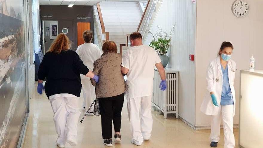 Cuidadores acompañan a una anciana en una residencia de mayores.