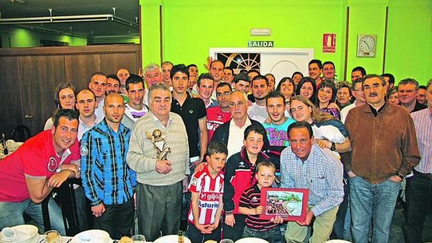 Los componentes de la peña rojiblanca arropan a los jugadores premiados del Sporting, ayer en Vioño.