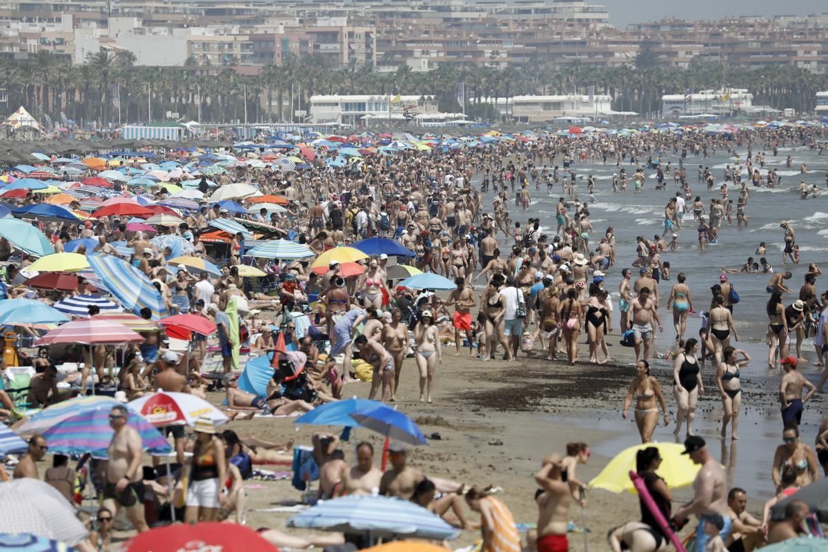 Miles de personas abarrotan la playa de la Malvarrosa de Valencia.
