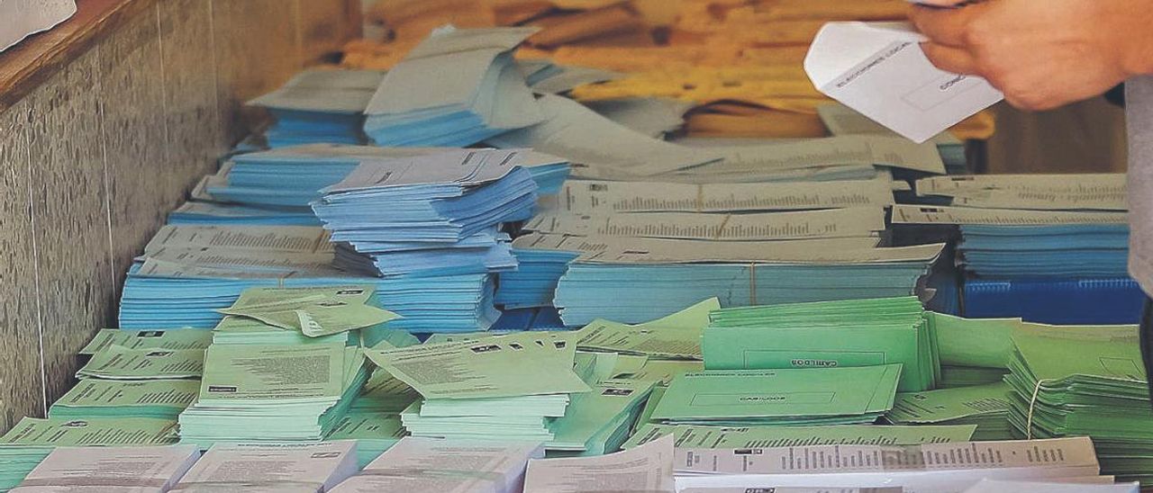 Una persona selecciona su papeleta antes de votar.