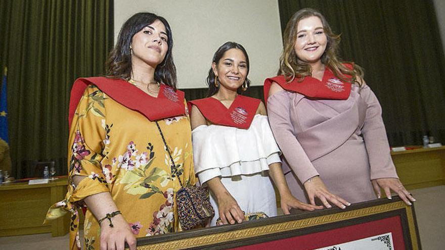 Alejandra Barrul, en el medio de dos compañeras, en el acto de licenciatura celebrado ayer.