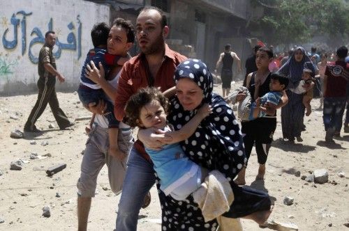 Palestinos huyen tras un ataque aéreo israelí contra una casa en la ciudad de Gaza.