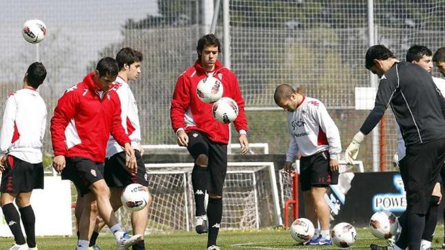 Iván Hernández, en el centro, domina un balón en el entrenamiento de ayer.