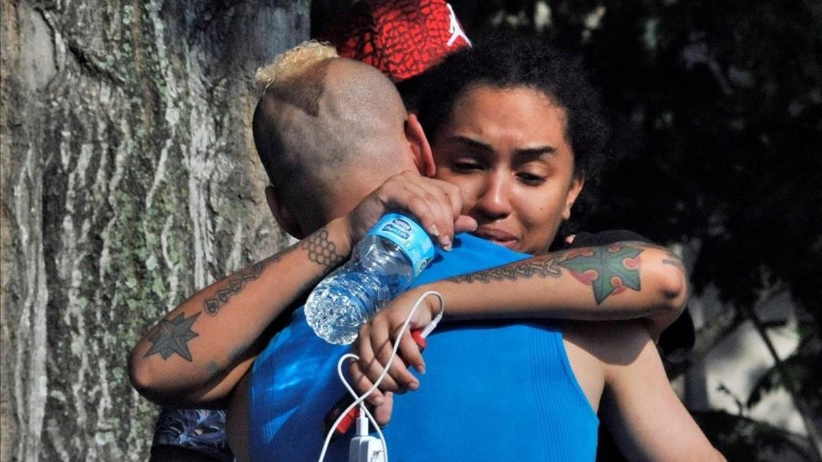 Amigos y familiares de los multiples heridos se abrazan frente al cuartel de la policía de Orlando