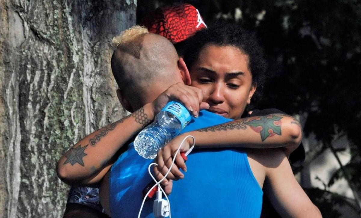 Friends and family members embrace outside the Orlando Police Headquarters