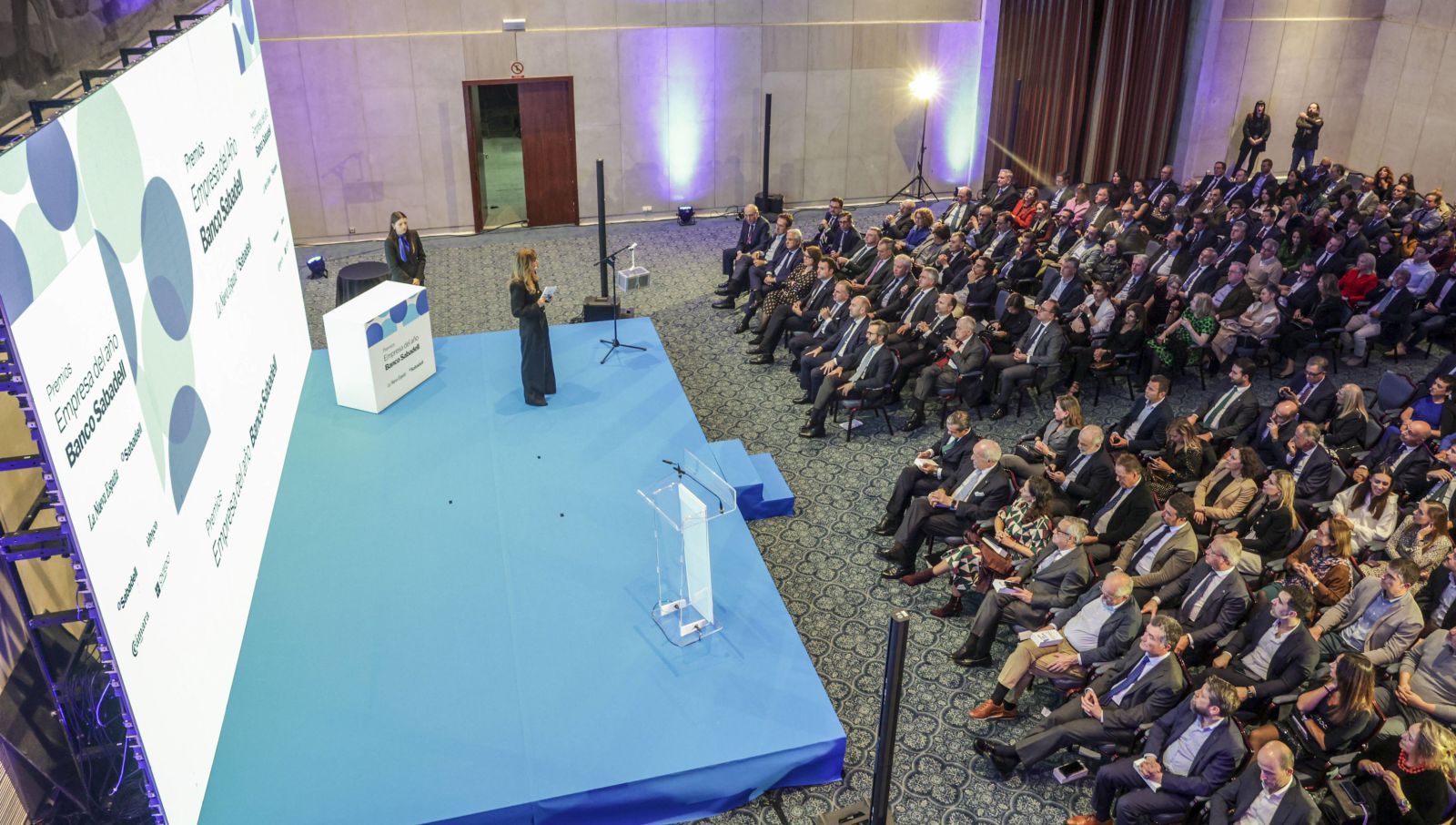 Vista general del acto. Debajo, un momento del cóctel y, a la derecha, el público aplaudiendo una  de las intervenciones. | Irma Collín / David Cabo