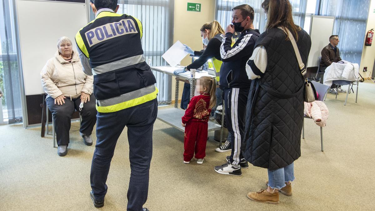 La policía toma imágenes de una refugiada para tramitar su documentación en Ciudad de la Luz