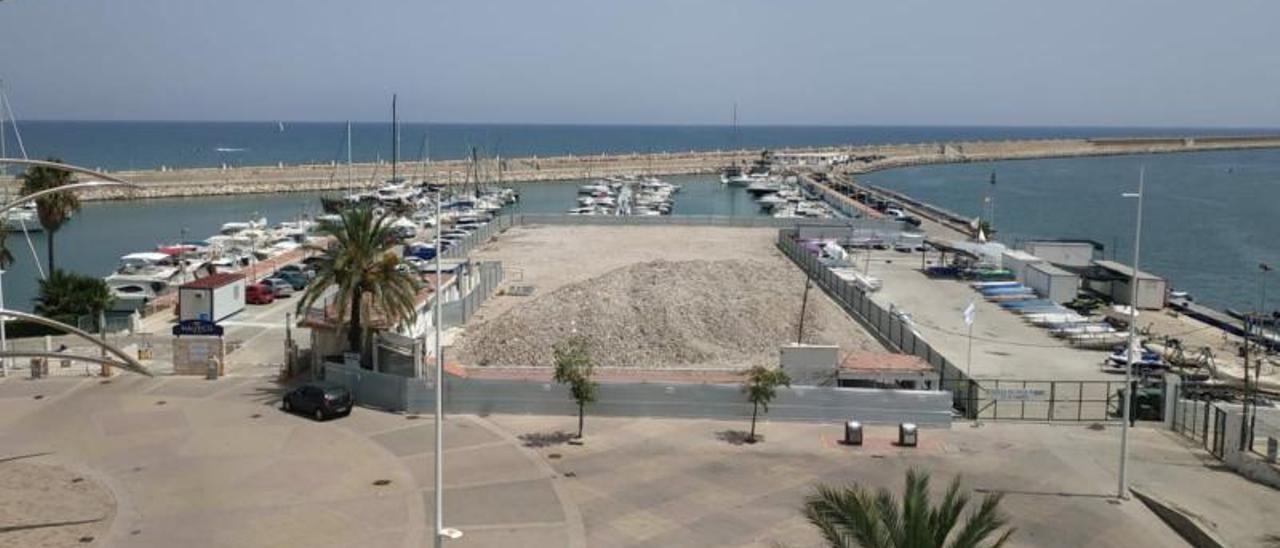 La explanada y la dársena del puerto deportivo del Club Náutico de Gandia, con los restos de la demolición del edificio social que se llevó a cabo hace un año. | LEVANTE-EMV