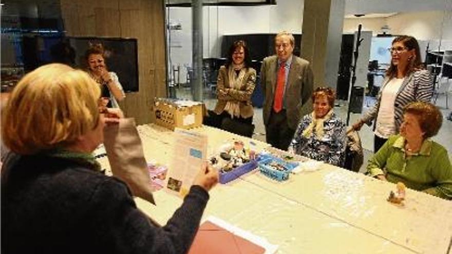 Lanaspa, al centre i acompanyat per Esther Planas i Maria Alsina, parlant amb usuàries de l&#039;EspaiCaixa.