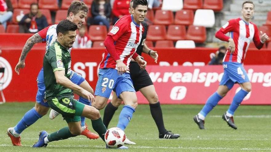 Sergio Álvarez intenta controlar un balón ante Cristian Salvador e Isma Cerro, con Juan Rodríguez al fondo.