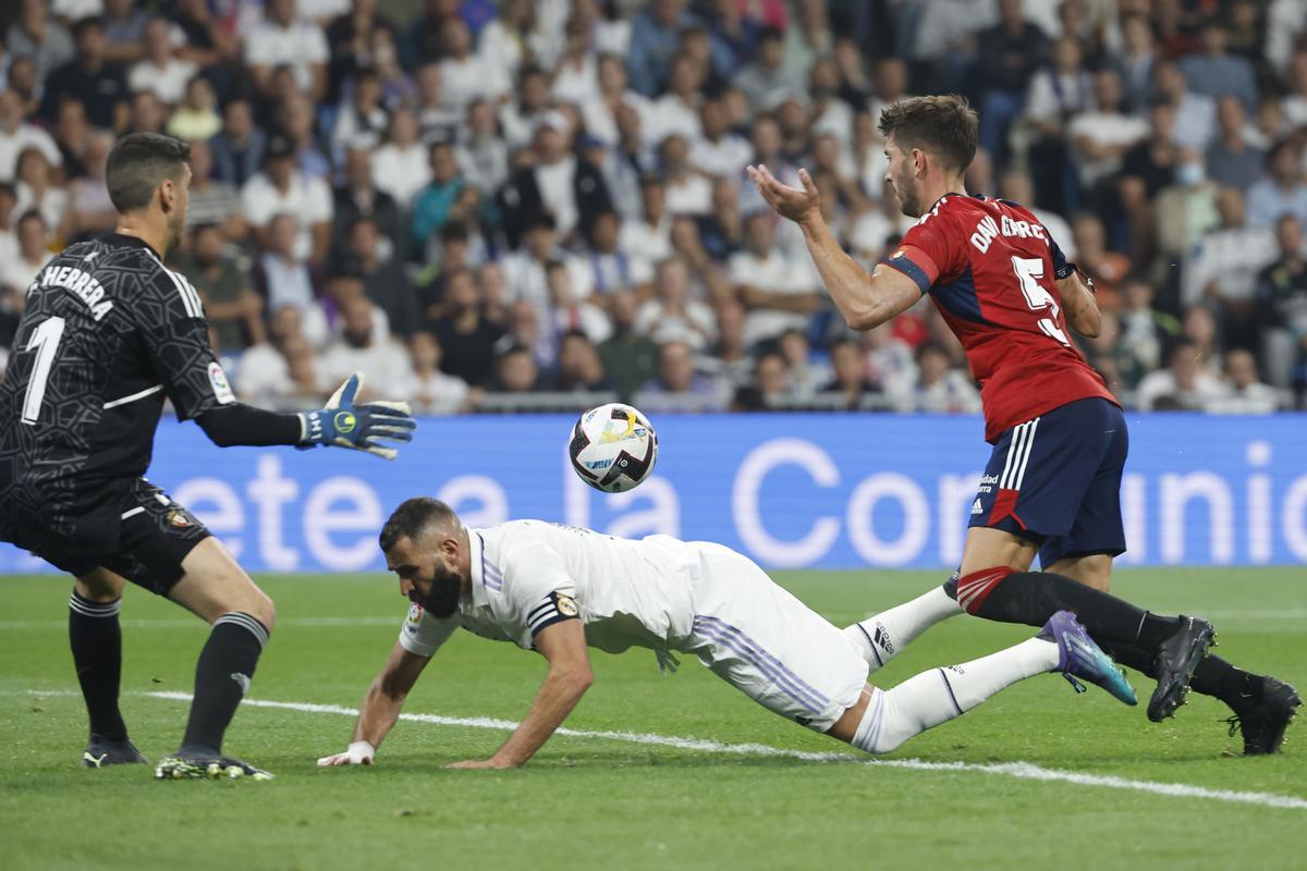 MADRID, 02/10/2022.- El delantero francés del Real Madrid, Karim Benzema (c), cae ante el defensa de Osasuna, David García (d), en la jugada que ha significado el penalti a favor del equipo blanco y la expulsión del defensor osasunista durante el encuentro correspondiente a la séptima jornada de primera división que disputan hoy domingo en el estadio Santiago Bernabéu, en Madrid. EFE / Chema Moya.