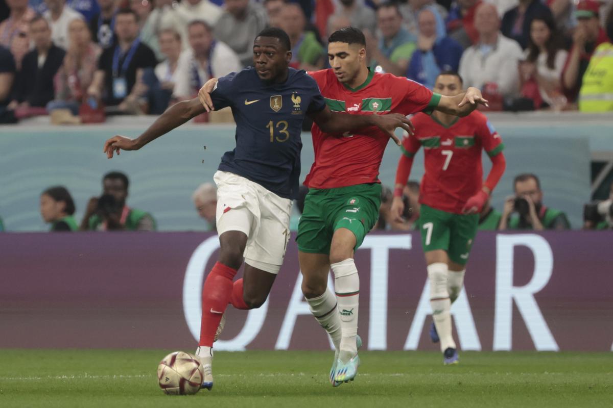 GR3053. AL BAIT (CATAR), 14/12/2022.- Youssouf Fofana (i) de Francia disputa un balón con Achraf Hakimi de Marruecos hoy, en un partido de semifinales del Mundial de Fútbol Qatar 2022 entre Francia y Marruecos en el estadio Al Bait en Jor (Catar). EFE/ Juan Ignacio Roncoroni