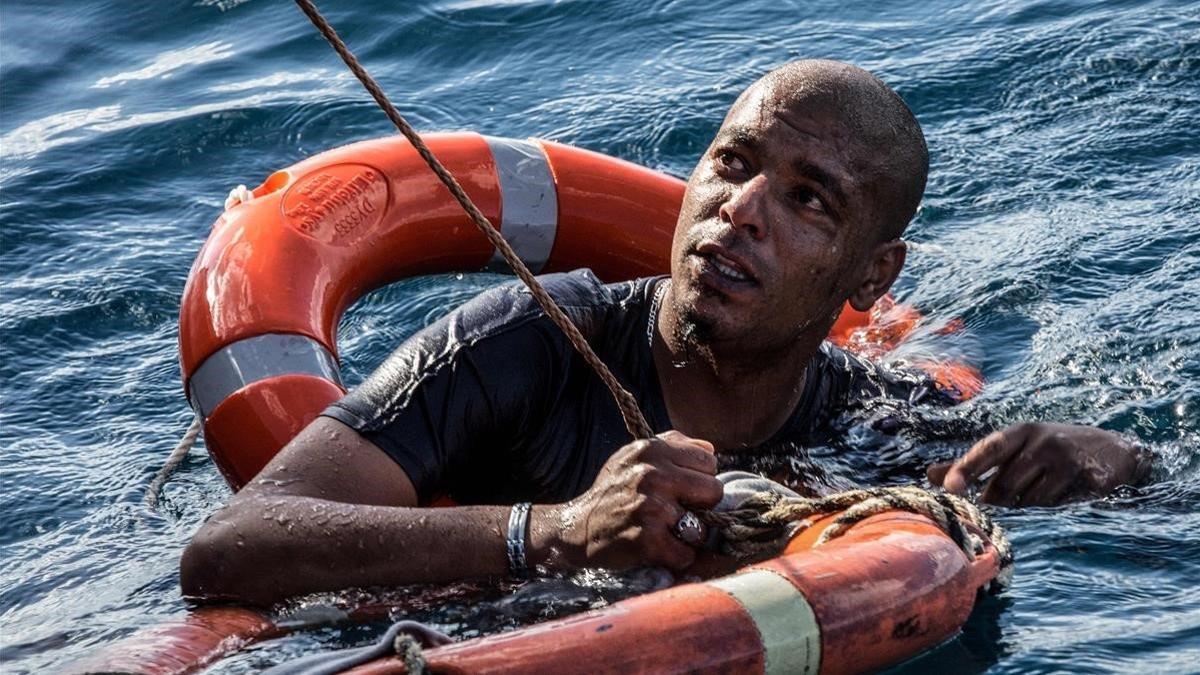 Un emigrante es rescatado con un salvavidas después de que se tirara al mar frente a la costa de Malta.