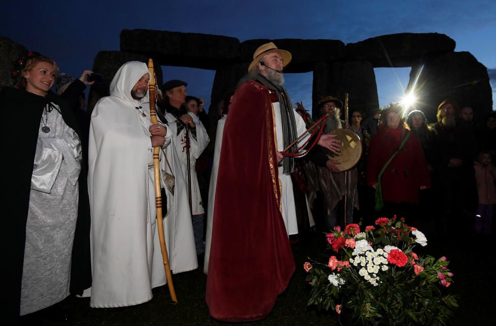 Miles de personas, varias de ellas disfrazadas de druidas, acudieron hoy al monumento de Stonehenge en Inglaterra para ver el amanecer con motivo del solsticio de invierno.